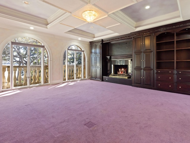 unfurnished living room with coffered ceiling, carpet, a high end fireplace, and crown molding