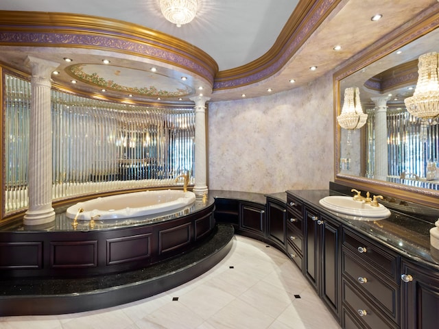 full bath featuring a garden tub, vanity, ornate columns, and ornamental molding