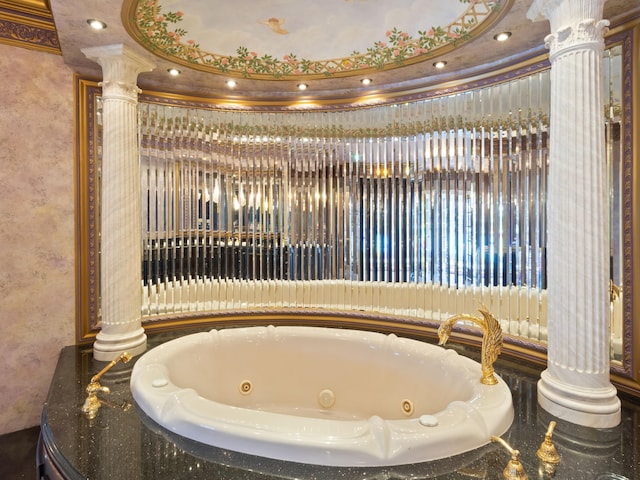 full bathroom featuring decorative columns and a whirlpool tub