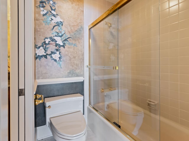 full bath with toilet and shower / bath combination with glass door