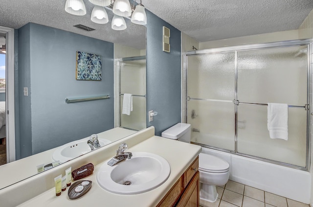 bathroom with tile patterned flooring, visible vents, toilet, vanity, and a textured ceiling