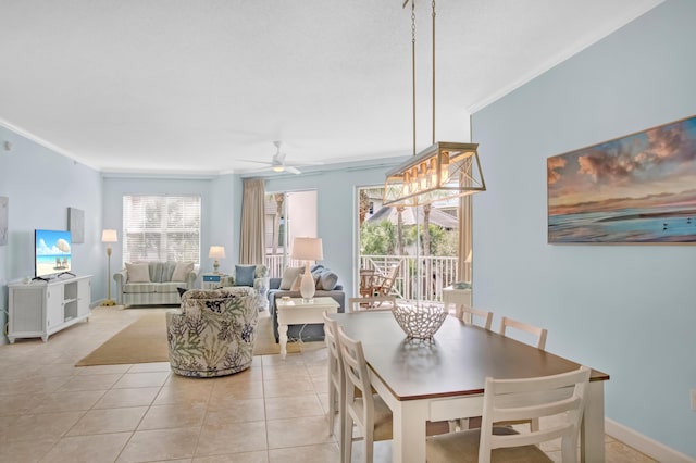 dining space featuring light tile patterned floors, a ceiling fan, baseboards, and ornamental molding