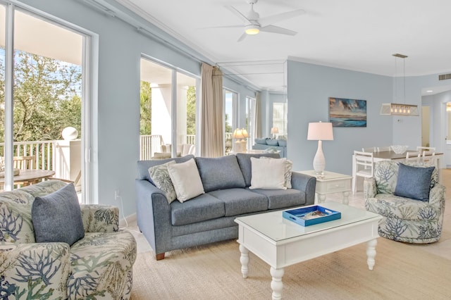 living area featuring crown molding, a healthy amount of sunlight, visible vents, and ceiling fan