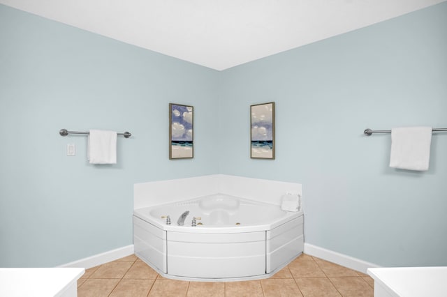 bathroom featuring baseboards, a jetted tub, and tile patterned flooring