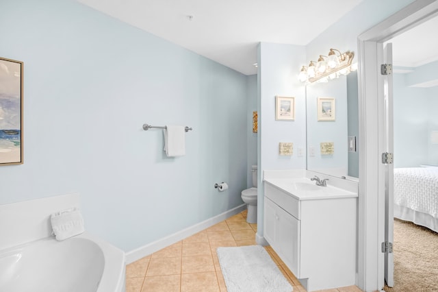 ensuite bathroom featuring connected bathroom, baseboards, toilet, tile patterned floors, and vanity