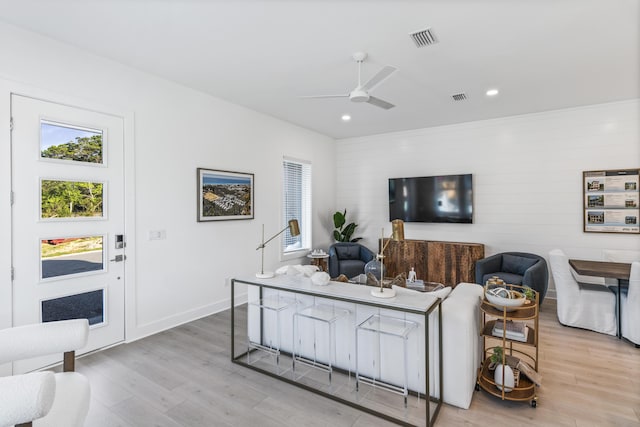 living room featuring a wealth of natural light, visible vents, a ceiling fan, and light wood finished floors