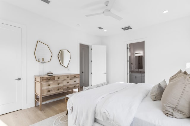 bedroom featuring ensuite bathroom, recessed lighting, visible vents, and light wood finished floors