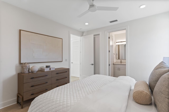 bedroom featuring light wood-type flooring, visible vents, ensuite bathroom, recessed lighting, and baseboards