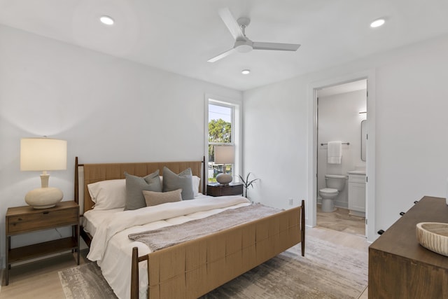 bedroom with a ceiling fan, recessed lighting, light wood-style floors, and connected bathroom