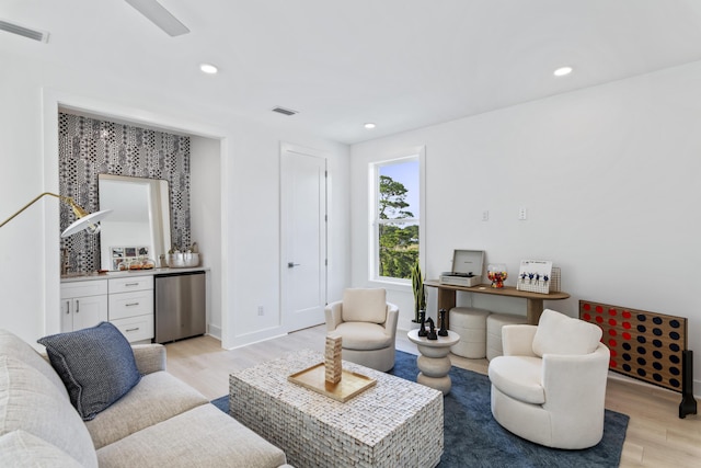 living area with light wood finished floors, visible vents, recessed lighting, and indoor bar