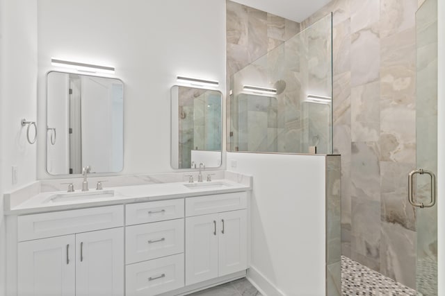 bathroom featuring a sink, a stall shower, and double vanity