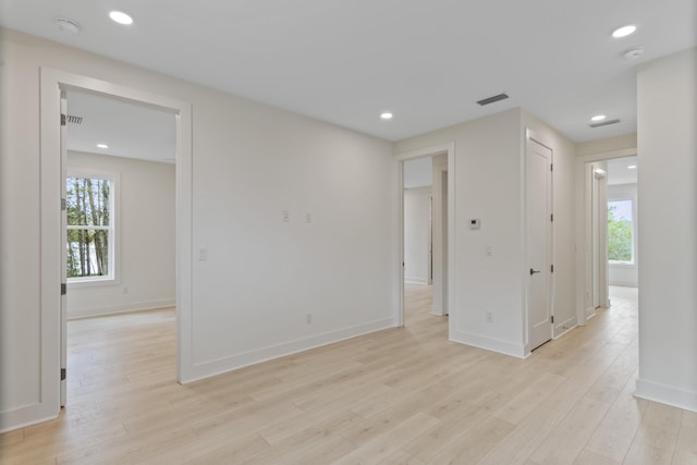 empty room with recessed lighting, a healthy amount of sunlight, and light wood finished floors