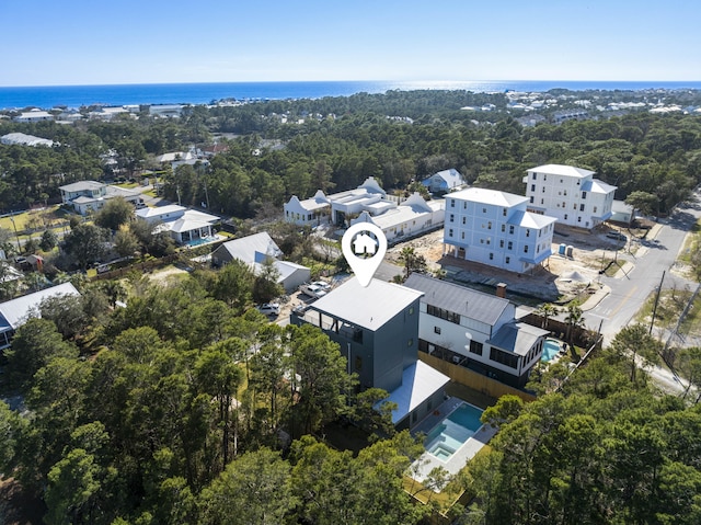 birds eye view of property with a wooded view and a water view