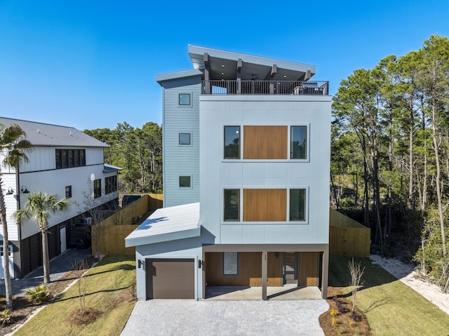 back of property with a balcony and decorative driveway