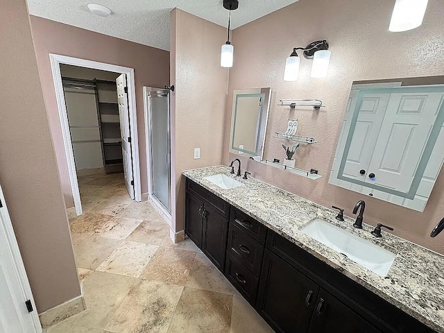 full bathroom with a sink, baseboards, and a stall shower