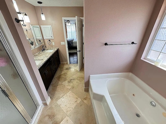 full bath with ensuite bath, a jetted tub, plenty of natural light, and double vanity