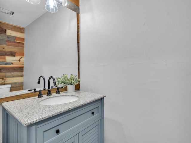 bathroom with vanity and wooden walls