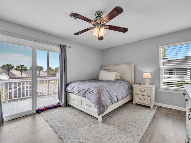 bedroom featuring baseboards, light wood-style flooring, a ceiling fan, and access to outside