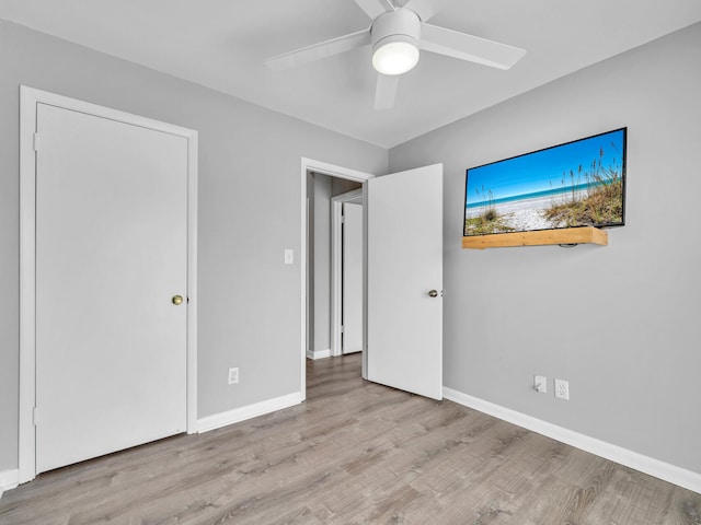 unfurnished bedroom with baseboards, wood finished floors, and a ceiling fan