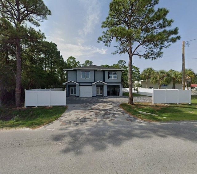 view of front facade with decorative driveway, fence, and a garage