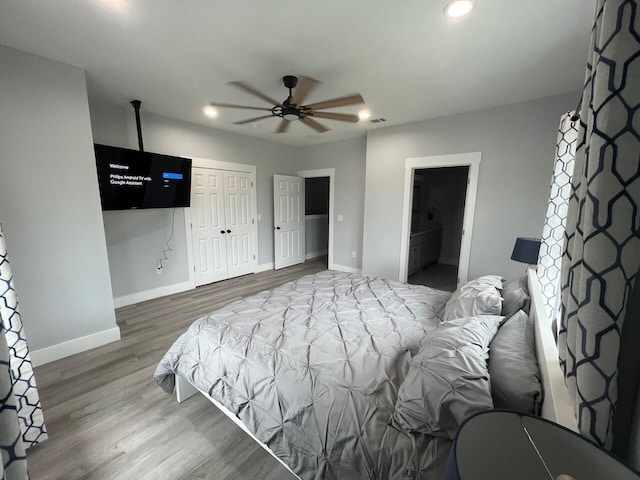 bedroom with wood finished floors, visible vents, baseboards, recessed lighting, and a closet