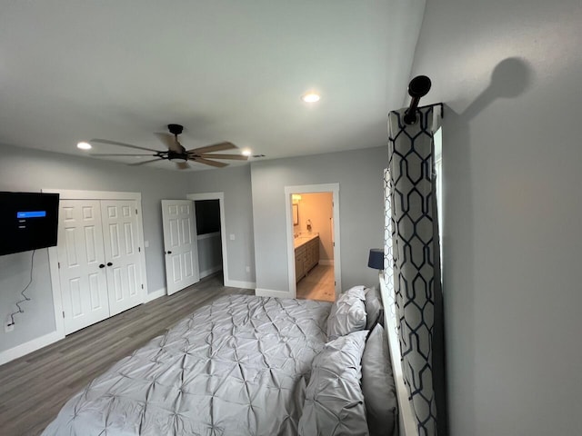 bedroom featuring baseboards, recessed lighting, wood finished floors, ensuite bath, and a ceiling fan