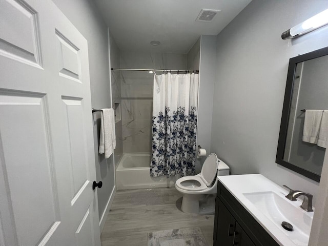 full bath featuring visible vents, toilet, shower / bath combo, wood finished floors, and vanity