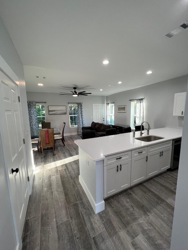 kitchen with visible vents, dark wood-type flooring, a sink, open floor plan, and light countertops