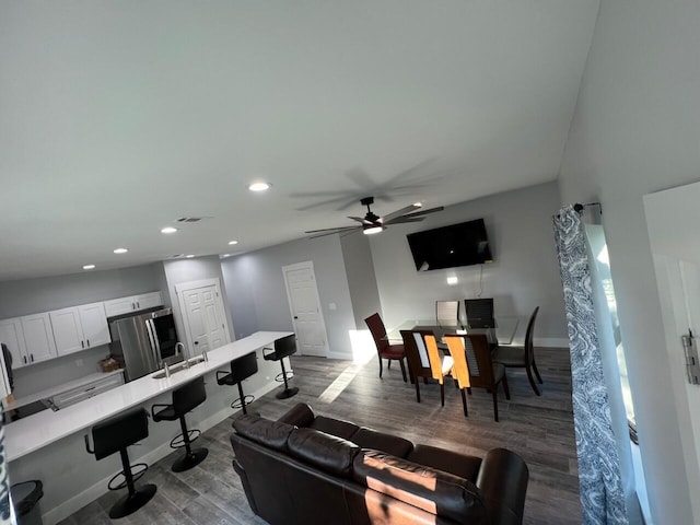 living area with visible vents, baseboards, recessed lighting, dark wood-style flooring, and ceiling fan