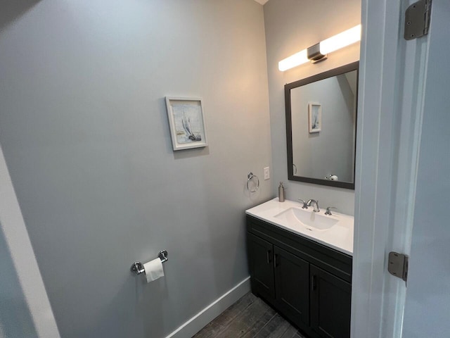 bathroom featuring vanity, wood finished floors, and baseboards