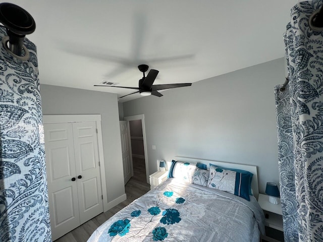 bedroom with a closet, baseboards, a ceiling fan, and wood finished floors