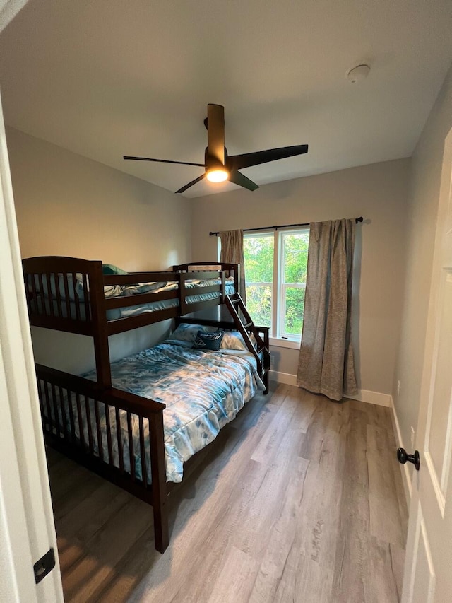 bedroom featuring a ceiling fan, wood finished floors, and baseboards