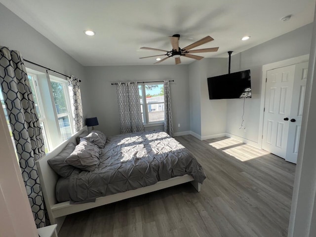 bedroom featuring recessed lighting, baseboards, multiple windows, and wood finished floors