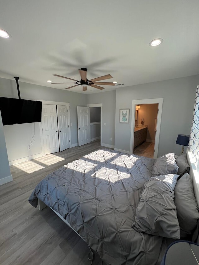 bedroom featuring a ceiling fan, wood finished floors, recessed lighting, a closet, and baseboards