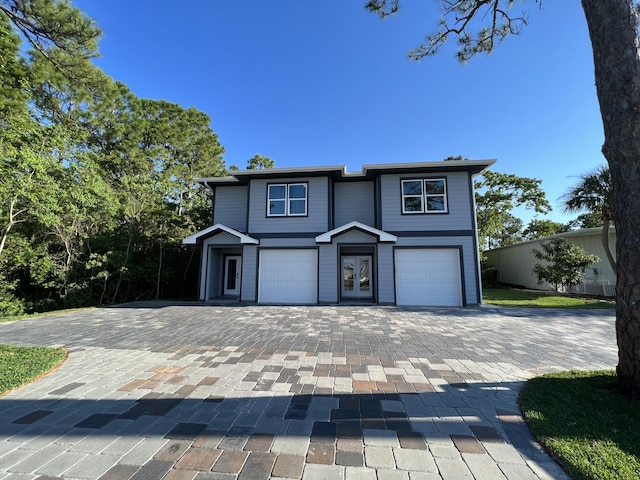 view of front of home with decorative driveway and an attached garage