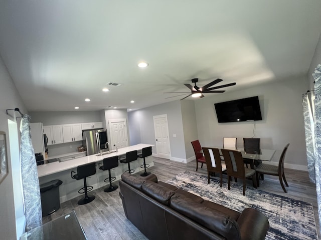 living room featuring recessed lighting, visible vents, baseboards, and wood finished floors