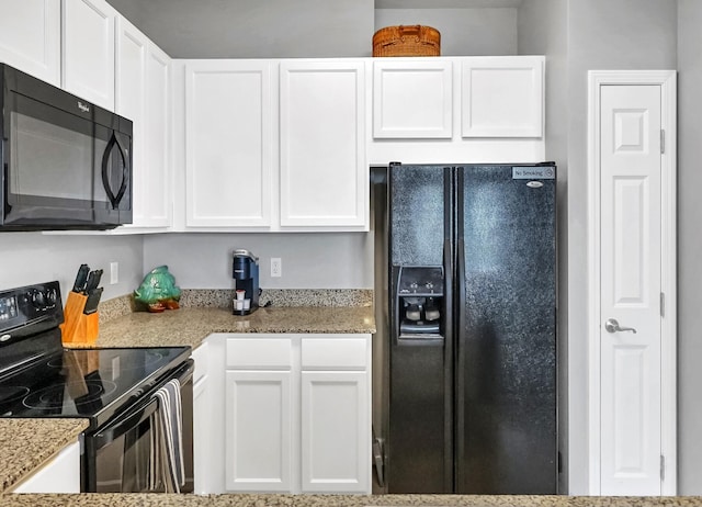 kitchen with white cabinetry, black appliances, and light stone countertops