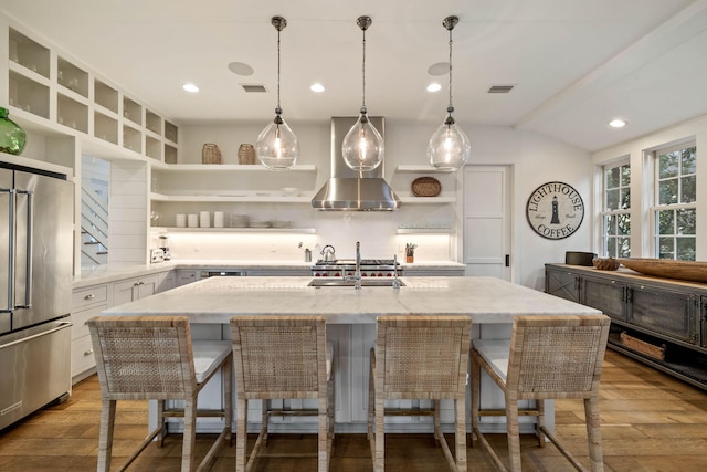 kitchen featuring light stone countertops, decorative backsplash, high quality fridge, wood finished floors, and open shelves