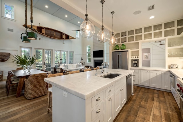 kitchen with dark wood-style flooring, visible vents, appliances with stainless steel finishes, and a sink