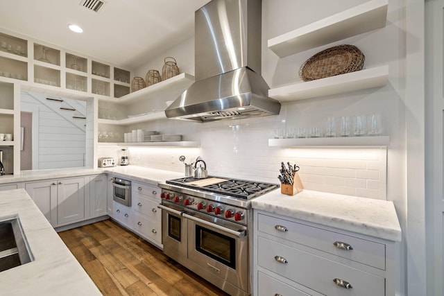 kitchen with tasteful backsplash, range hood, range with two ovens, and open shelves