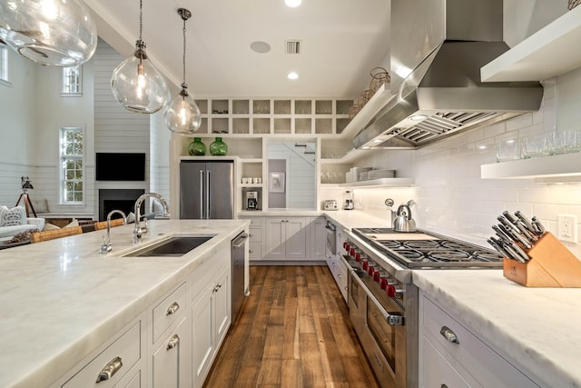 kitchen with visible vents, open shelves, a sink, wall chimney exhaust hood, and high end appliances