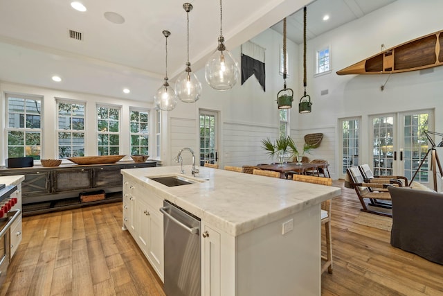 kitchen with visible vents, light wood-type flooring, a sink, french doors, and dishwasher