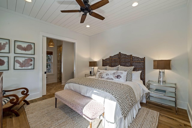 bedroom featuring wooden ceiling, wood finished floors, baseboards, and ornamental molding