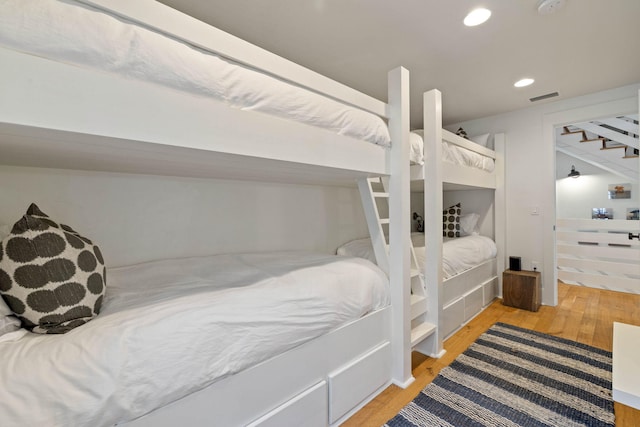 bedroom with recessed lighting, wood finished floors, and visible vents