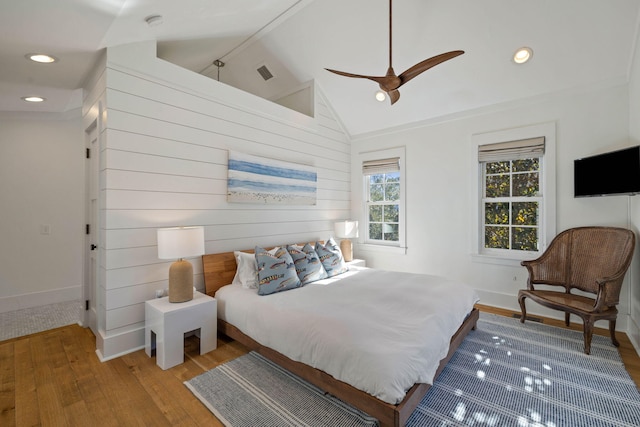 bedroom with visible vents, baseboards, lofted ceiling, recessed lighting, and wood finished floors