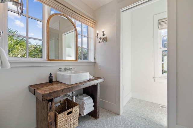 bathroom with a sink and baseboards