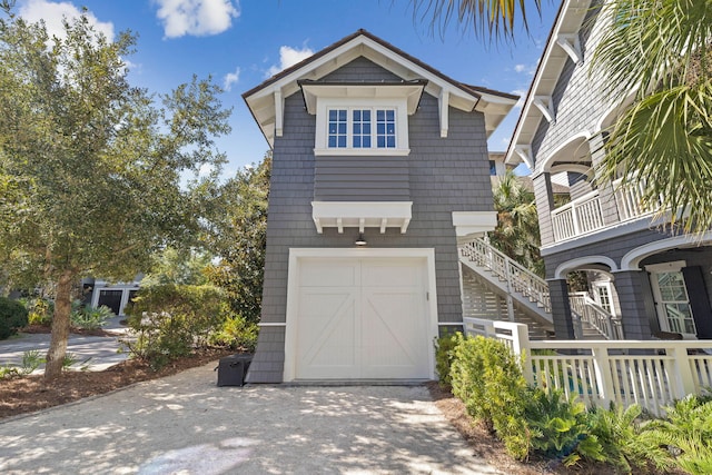 view of front of house featuring stairway, driveway, and an attached garage