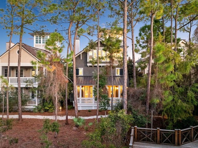 view of front facade with a chimney, a standing seam roof, and metal roof