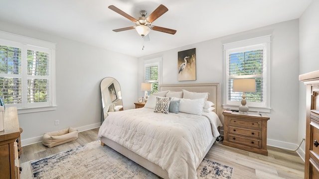 bedroom with light wood-type flooring, baseboards, and a ceiling fan