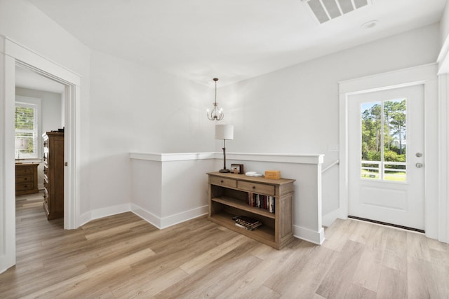 foyer entrance featuring visible vents, baseboards, and wood finished floors